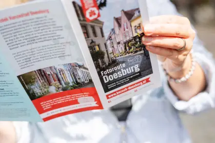 Vrouw met folder van Fotoroute Doesburg